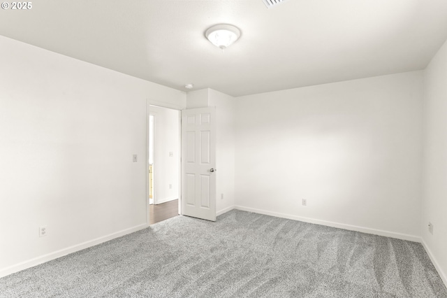 carpeted empty room with baseboards