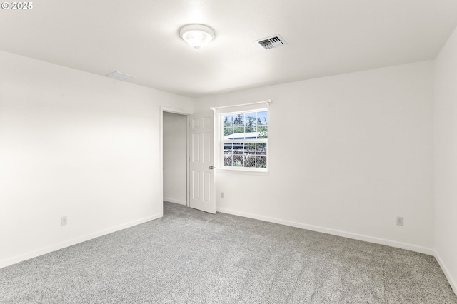 carpeted empty room featuring baseboards