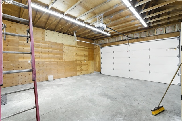 garage with a garage door opener and wood walls