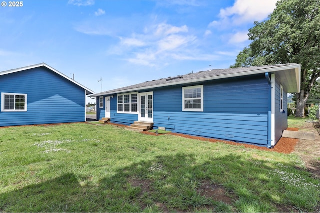 rear view of property with entry steps and a yard