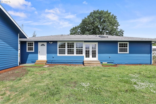 rear view of house featuring entry steps, a yard, and french doors