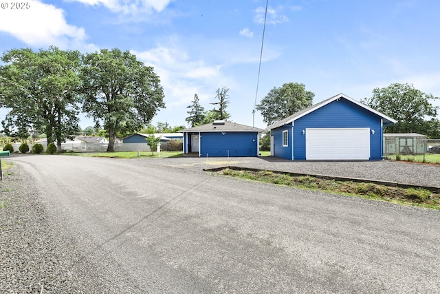 ranch-style home with fence and an outbuilding