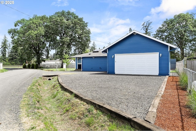 view of front of house with fence, driveway, and an attached garage
