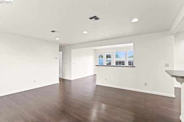 unfurnished living room with recessed lighting, baseboards, and dark wood-style flooring