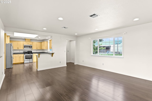 unfurnished living room with dark wood-style floors, recessed lighting, and baseboards