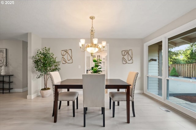 dining room with an inviting chandelier, baseboards, and visible vents