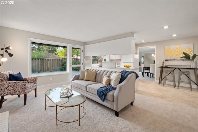 living room with baseboards, light carpet, and recessed lighting