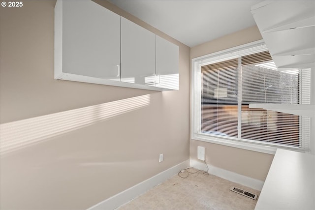 laundry room featuring baseboards, a wealth of natural light, and visible vents