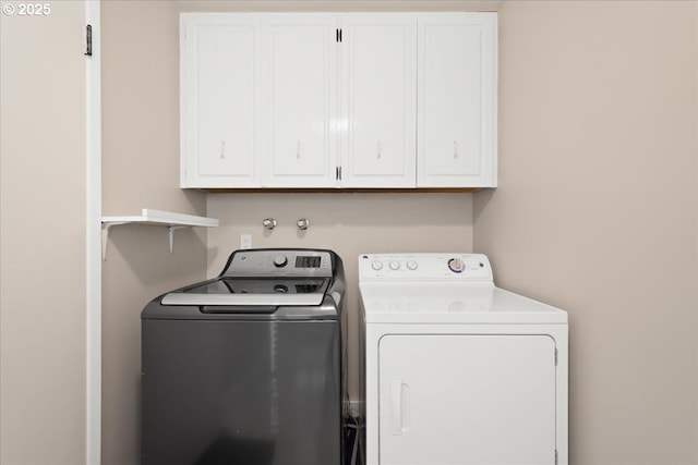 clothes washing area with cabinet space and washer and clothes dryer
