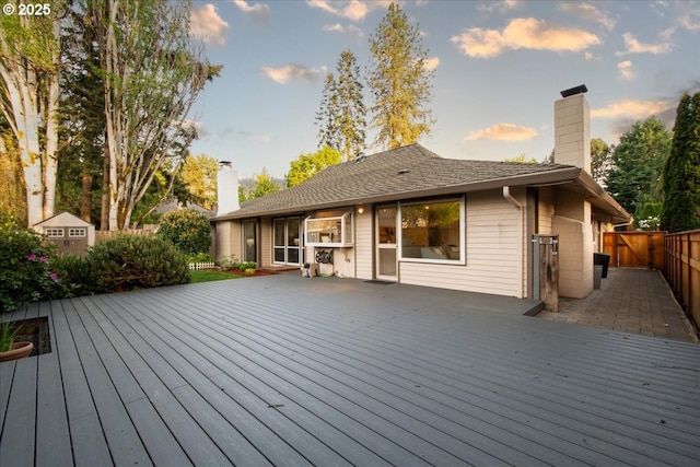 deck at dusk featuring fence