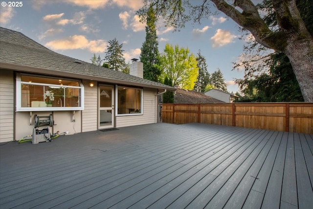 deck at dusk featuring fence