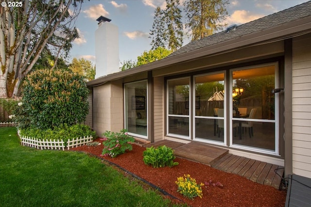 view of side of home featuring a lawn and a chimney