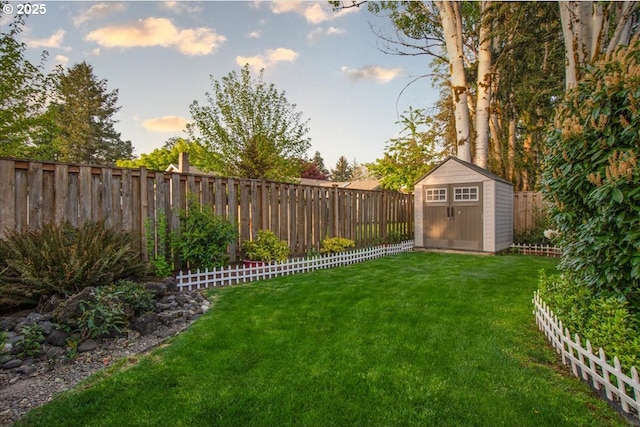 view of yard featuring an outbuilding, a shed, and a fenced backyard
