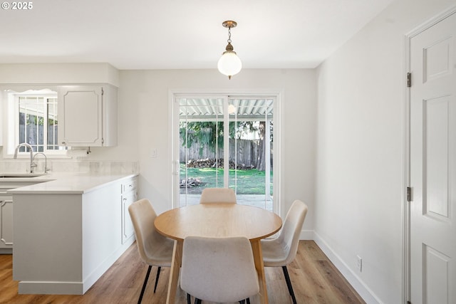 dining space with light wood-style flooring and baseboards