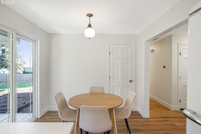 dining area featuring baseboards and light wood-style floors