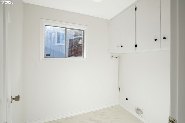 laundry room featuring marble finish floor, electric dryer hookup, baseboards, and cabinet space