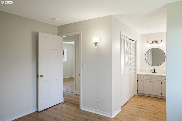 bathroom featuring wood finished floors, vanity, and baseboards