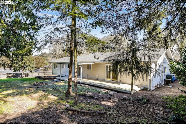 rear view of property with a deck, central AC, and fence