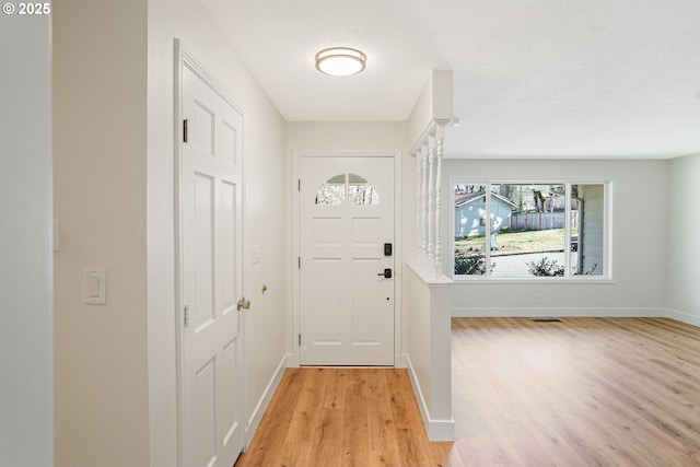 doorway to outside featuring light wood-style flooring and baseboards