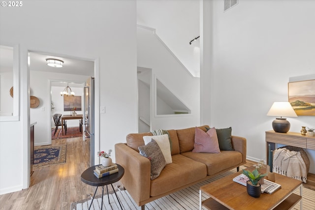 living room featuring an inviting chandelier and light hardwood / wood-style flooring