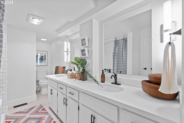 bathroom with tile patterned flooring, vanity, and toilet