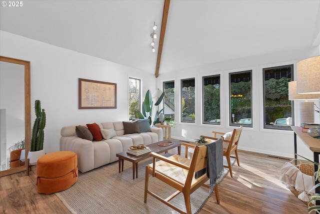 living room with vaulted ceiling with beams and light wood-type flooring