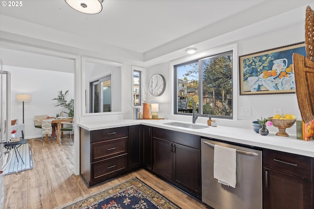 kitchen featuring dark brown cabinetry, sink, light hardwood / wood-style floors, and dishwasher