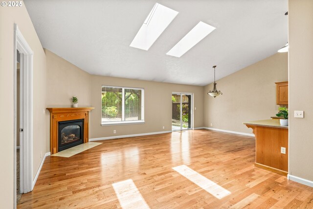 3473 Parker Ln, Springfield, OR 97477 - unfurnished living room with lofted ceiling, a fireplace with flush hearth, light wood-style flooring, a skylight, and baseboards