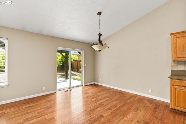 3473 Parker Ln, Springfield, OR 97477 - unfurnished dining area with light wood-style floors, baseboards, and lofted ceiling