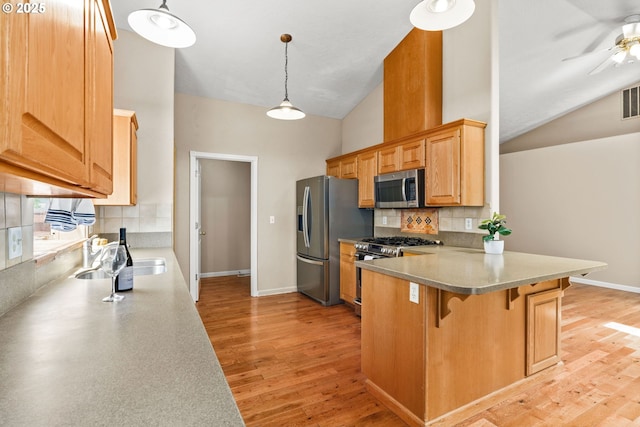 3473 Parker Ln, Springfield, OR 97477 - kitchen with stainless steel appliances, a breakfast bar, backsplash, a peninsula, and a sink