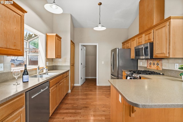 3473 Parker Ln, Springfield, OR 97477 - kitchen with appliances with stainless steel finishes, a sink, light wood finished floors, decorative backsplash, and hanging light fixtures