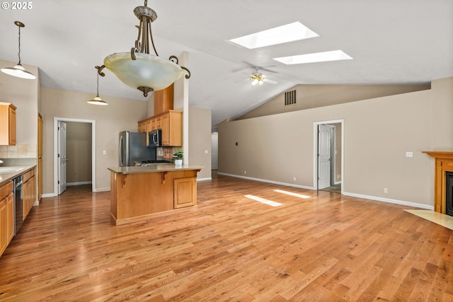 3473 Parker Ln, Springfield, OR 97477 - kitchen featuring a skylight, open floor plan, stainless steel appliances, light wood-style floors, and a breakfast bar