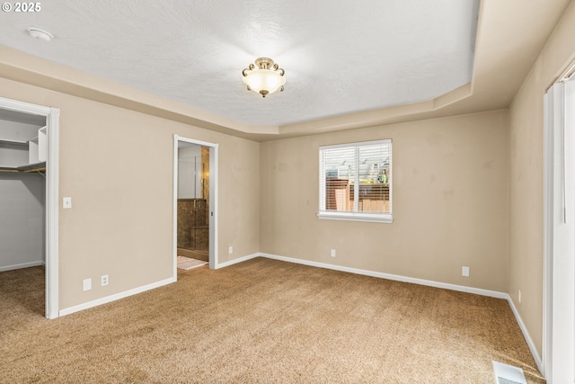 3473 Parker Ln, Springfield, OR 97477 - unfurnished bedroom with a spacious closet, carpet flooring, baseboards, ensuite bathroom, and a raised ceiling