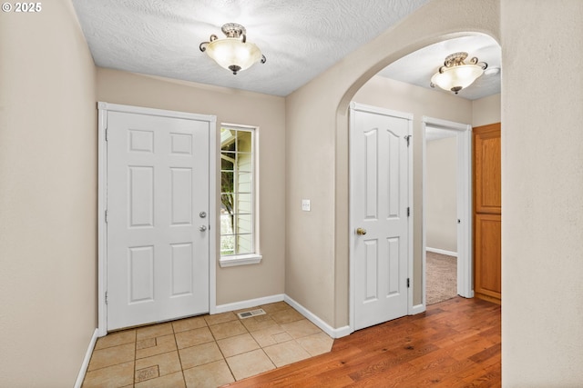 3473 Parker Ln, Springfield, OR 97477 - foyer featuring arched walkways, light wood finished floors, baseboards, and a textured ceiling