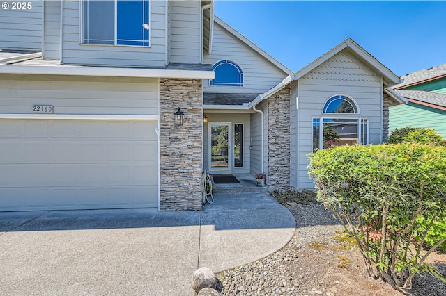 22160 NE Lachenview Ln, Fairview, OR 97024 - property entrance with stone siding, an attached garage, and concrete driveway
