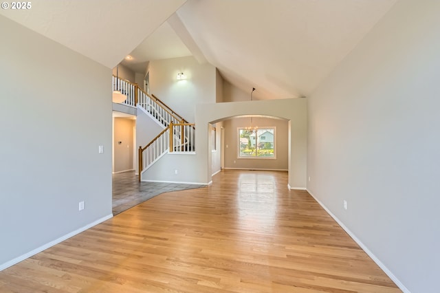 22160 NE Lachenview Ln, Fairview, OR 97024 - unfurnished living room featuring arched walkways, high vaulted ceiling, light wood-style floors, a chandelier, and stairs