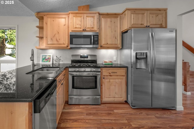 1629 NW Orchard Ave, Gresham, OR 97030 - kitchen with stainless steel appliances, a sink, wood finished floors, dark stone counters, and light brown cabinetry