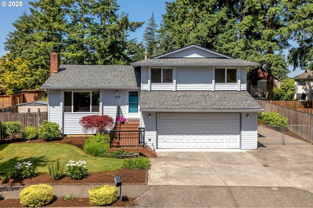1629 NW Orchard Ave, Gresham, OR 97030 - tri-level home featuring an attached garage, a chimney, a shingled roof, and driveway