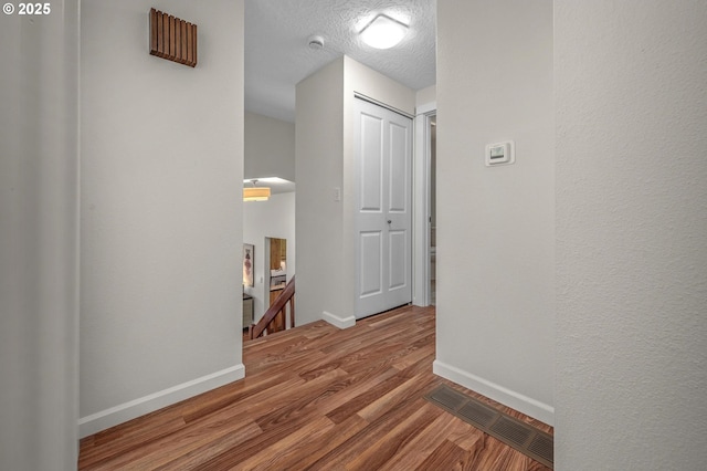 1629 NW Orchard Ave, Gresham, OR 97030 - hallway with an upstairs landing, wood finished floors, baseboards, and a textured ceiling