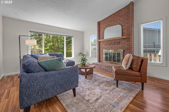 1629 NW Orchard Ave, Gresham, OR 97030 - living area featuring a brick fireplace, baseboards, a textured ceiling, wood finished floors, and lofted ceiling