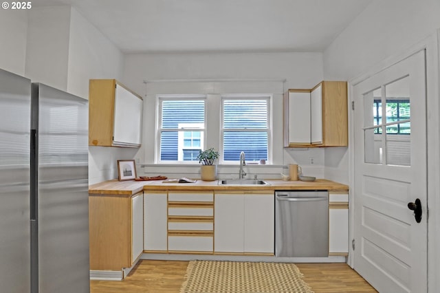 26 NW 22nd Pl, Portland, OR 97210 - kitchen featuring appliances with stainless steel finishes, a sink, plenty of natural light, and light wood-style flooring