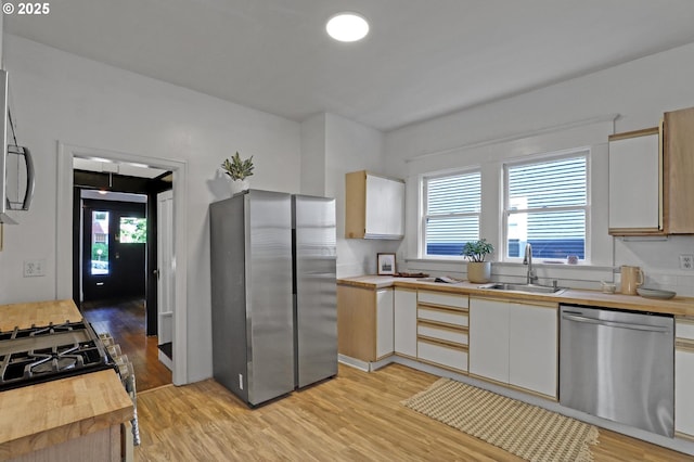 26 NW 22nd Pl, Portland, OR 97210 - kitchen featuring stainless steel appliances, a sink, wood counters, light wood-style flooring, and plenty of natural light