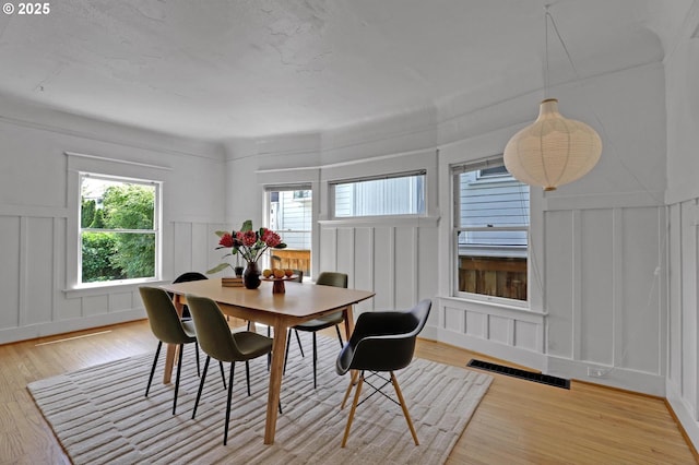 26 NW 22nd Pl, Portland, OR 97210 - dining room with a decorative wall, light wood-style flooring, and wainscoting