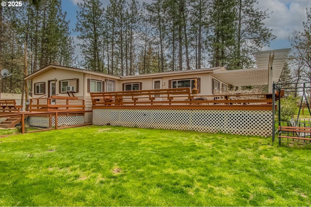 rear view of house featuring a wooden deck and a yard