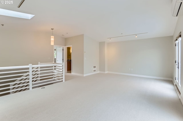 325 NE Graham St Unit 10, Portland, OR 97212 - empty room with light carpet, a skylight, a wall unit AC, track lighting, and baseboards