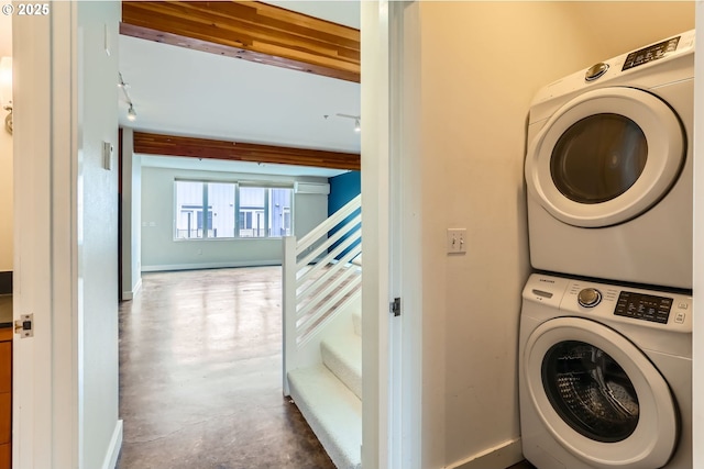 325 NE Graham St Unit 10, Portland, OR 97212 - laundry area with stacked washing machine and dryer, a wall unit AC, and baseboards