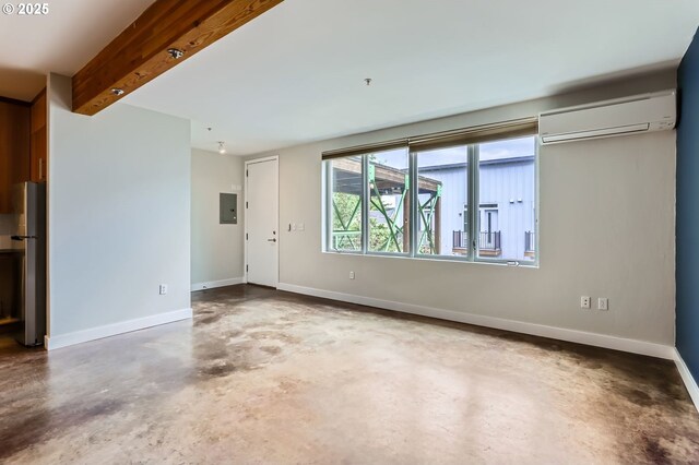 325 NE Graham St Unit 10, Portland, OR 97212 - spare room featuring a wall mounted air conditioner, unfinished concrete flooring, electric panel, and baseboards