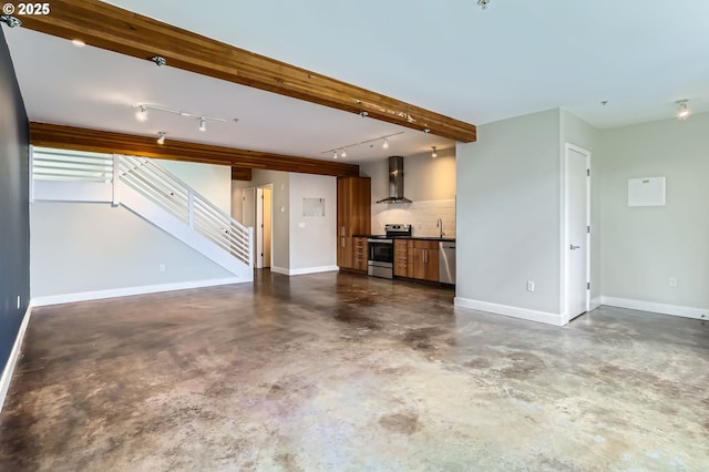 325 NE Graham St Unit 10, Portland, OR 97212 - unfurnished living room featuring concrete floors, rail lighting, a sink, and stairway