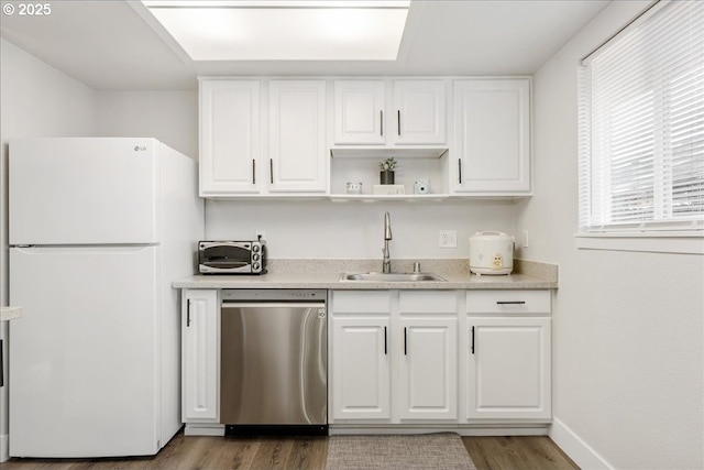 kitchen featuring white cabinets, white refrigerator, stainless steel dishwasher, and sink