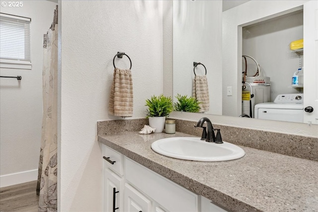 bathroom with hardwood / wood-style floors, vanity, and washer / clothes dryer